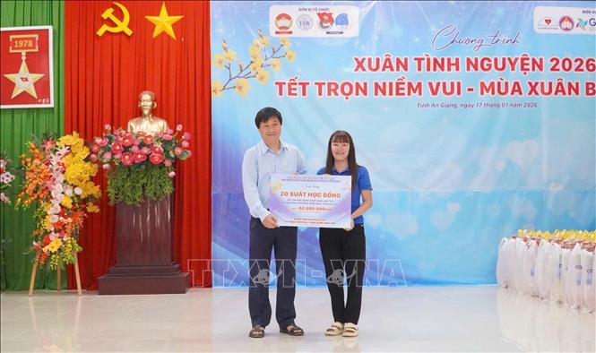 Đại diện Ban tổ chức trao 20 suất học bổng trị giá 40 triệu đồng cho học sinh có hoàn cảnh khó khăn vượt khó, hiếu học trên địa bàn phường Thới Sơn. Ảnh: Công Mạo-TTXVN