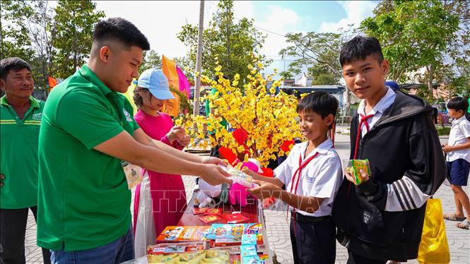 Các thiếu nhi phấn khởi nhận quà Tết và học bổng trong chương trình. Ảnh: Minh Phú – TTVXN