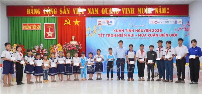Đại diện Ban tổ chức trao học bổng cho học sinh có hoàn cảnh khó khăn vượt khó, hiếu học. Ảnh: Công Mạo-TTXVN