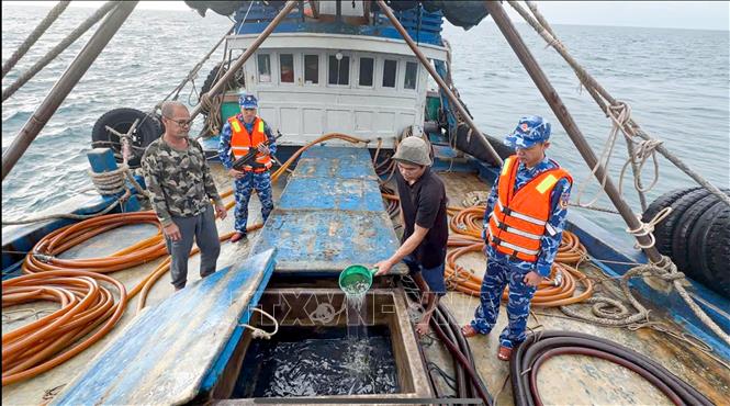 Lực lượng chức năng Bộ Tư lệnh Vùng Cảnh sát biển 4 kiểm tra hàng hóa trên tàu cá TG 92232 TS. Ảnh: TTXVN phát