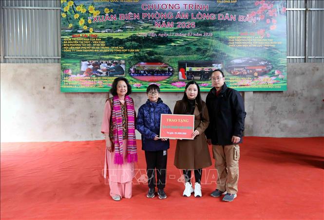 Trao áo ấm cho cô giáo và học sinh trên địa bàn xã Lóng Sập. Ảnh: Quang Quyết - TTXVN