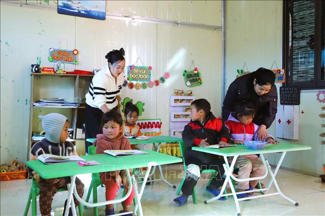 Hai cô giáo Nguyễn Thị Trâm, Ngân Thị Chiến, giáo viên cắm bản tại điểm trường Mầm non Huồi Măn đang phụ trách lớp học có 5 cháu trong giờ tập tô. Ảnh: Xuân Tiến - TTXVN 