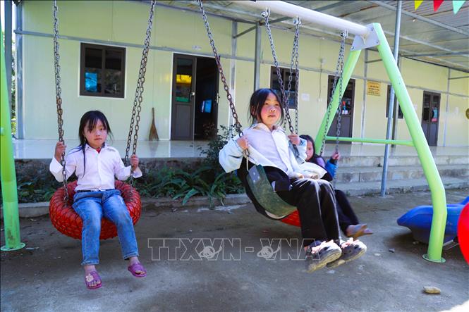 Các cháu học sinh nữ điểm trường Phổ thông dân tộc bán trú Tiểu học bản Huồi Măn (xã Nhôn Mai, tỉnh Nghệ An) chơi xích đu trong lúc chờ thời gian vào lớp học. Ảnh: Xuân Tiến - TTXVN 