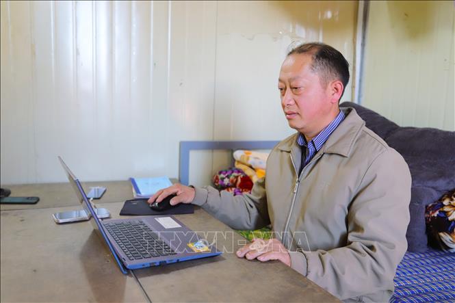 Thầy giáo Và Bá Chái, điểm trường Phổ thông dân tộc bán trú Tiểu học đang soạn giáo án giảng dạy tại căn phòng nhỏ là nơi ngủ nghỉ, sinh hoạt tại điểm trường. Ảnh: Xuân Tiến - TTXVN 