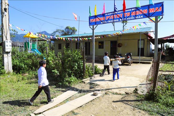 Học sinh theo học tại điểm trường Phổ thông dân tộc bán trú trong bản Huồi Măn đến lớp mang theo củi khô để đốt lửa, sưởi ấm phòng khi nhiệt độ giảm sâu, thời tiết giá lạnh. Ảnh: Xuân Tiến - TTXVN 