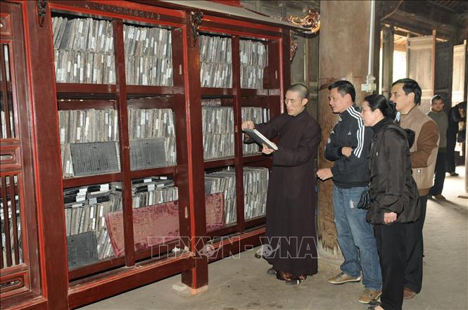 Du khách chiêm ngưỡng kho mộc bản chùa Vĩnh Nghiêm. Ảnh: Việt Hùng – TTXVN
