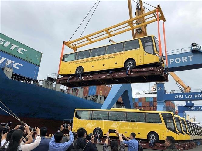 Kinh tế tăng trưởng khá, nền kinh tế thị trường định hướng xã hội chủ nghĩa từng bước hình thành, phát triển. Trong ảnh: Lễ bàn giao 15 xe Bus THACO thương hiệu Việt Nam xuất khẩu sang Philippines, tại cảng Chu Lai (Khu kinh tế mở Chu Lai, tỉnh Quảng Nam khánh thành năm 2003). Ảnh: Trần Tĩnh - TTXVN