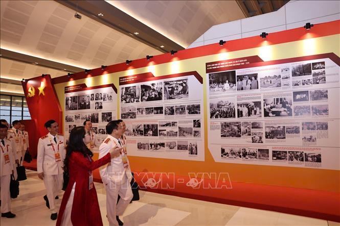 Đại biểu xem Trưng bày ảnh “Dưới cờ Đảng - Đất nước tiến vào Kỷ nguyên mới” do Thông tấn xã Việt Nam thực hiện. Ảnh: TTXVN
