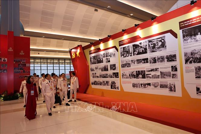 Đại biểu xem Trưng bày ảnh “Dưới cờ Đảng - Đất nước tiến vào Kỷ nguyên mới” do Thông tấn xã Việt Nam thực hiện. Ảnh: TTXVN
