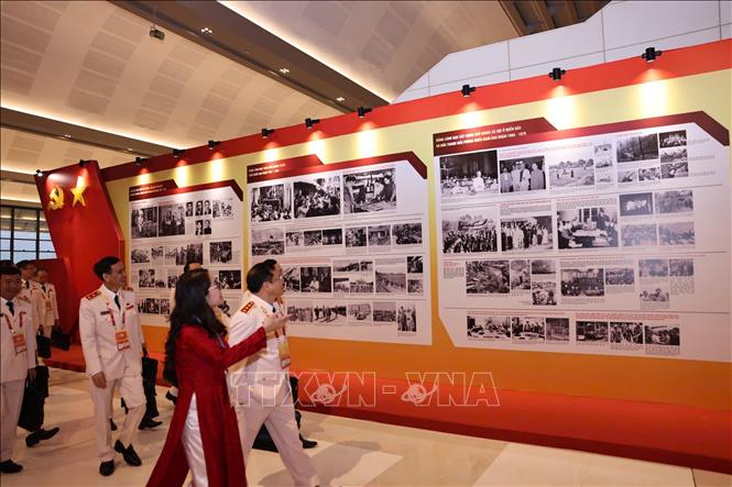 Đại biểu xem Trưng bày ảnh “Dưới cờ Đảng - Đất nước tiến vào Kỷ nguyên mới” do Thông tấn xã Việt Nam thực hiện. Ảnh: TTXVN

