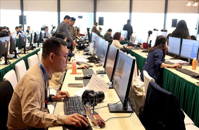 Phóng viên, biên tập viên tác nghiệp tại Trung tâm báo chí của Đại hội. Ảnh: TTXVN