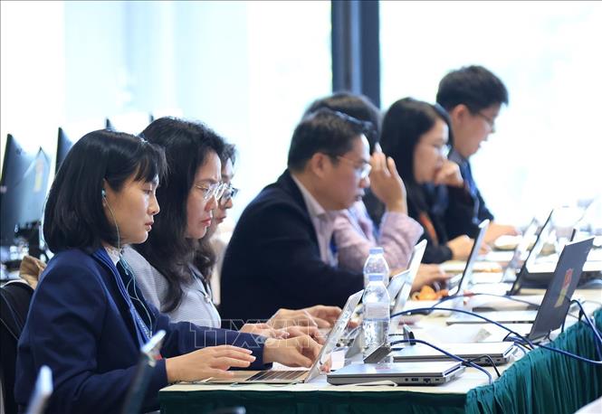 Phóng viên, biên tập viên tác nghiệp tại Trung tâm báo chí của Đại hội. Ảnh: TTXVN