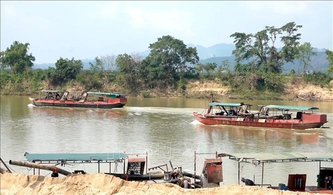 Tại khu vực xã Yên Xuân (Nghệ An), hoạt động khai thác cát trên sông Lam diễn ra khá sôi động, tuy nhiên,  hầu hết các tàu thuyền tham gia khai thác đều chưa được cơ quan chức năng đăng ký, đăng kiểm. Ảnh: Văn Tý-TTXVN