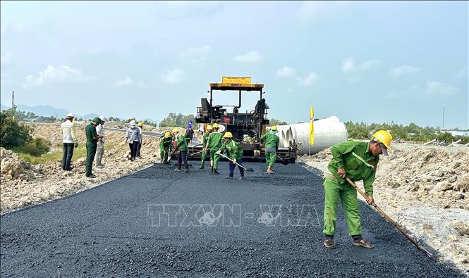 Công nhân khẩn trương thi công trải nhựa mặt đường dẫn vào cao tốc tại phường Vĩnh Tế, tỉnh An Giang. Ảnh: Thanh Sang-TTXVN