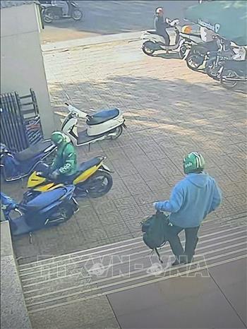 Các đối tượng dùng súng cướp ngân hàng. Ảnh: Chụp màn hình camera - TTXVN