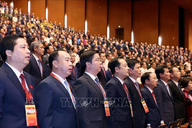 Các đại biểu dự phiên khai mạc Đại hội XIV của Đảng thực hiện nghi thức chào cờ. Ảnh: TTXVN
