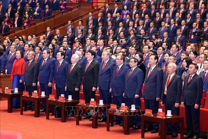 Các đồng chí lãnh đạo, nguyên lãnh đạo Đảng, Nhà nước và đại biểu thực hiện nghi lễ chào cờ. Ảnh: TTXVN
