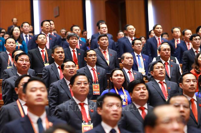 Các đại biểu dự phiên khai mạc Đại hội XIV thực hiện nghi thức chào cờ. Ảnh: TTXVN
