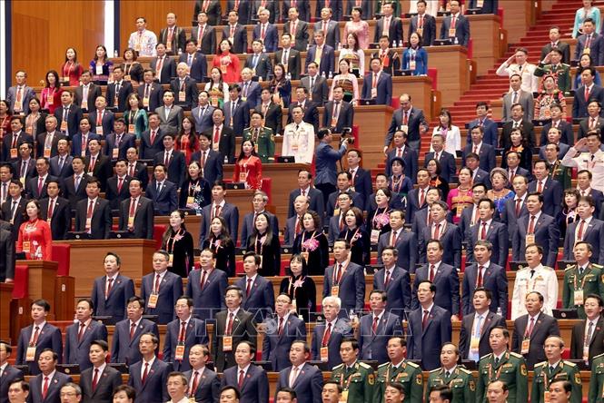 Các đại biểu dự phiên khai mạc thực hiện nghi thức chào cờ. Ảnh: TTXVN