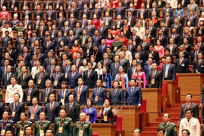 Các đại biểu dự phiên khai mạc thực hiện nghi thức chào cờ. Ảnh: TTXVN