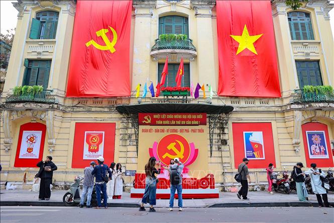 Young people take photos in the front of Hanoi Moi Newspaper's headquarter in Hanoi. VNA Photo