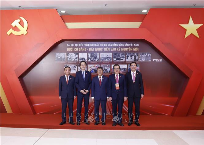 Các đại biểu chụp ảnh lưu niệm ở khu trưng bày ảnh của Thông tấn xã Việt Nam tại phiên khai mạc Đại hội XIV của Đảng. Ảnh: TTXVN