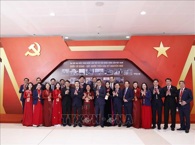Các đại biểu chụp ảnh lưu niệm ở khu trưng bày ảnh của Thông tấn xã Việt Nam tại phiên khai mạc Đại hội XIV của Đảng. Ảnh: TTXVN