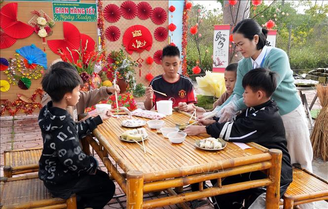 Trẻ khuyết tật nghe – nói tham gia các hoạt động trải nghiệm ẩm thực trong chương trình “Bánh chưng xanh – Chợ Tết quê em”. Ảnh: Đồng Thúy-TTXVN