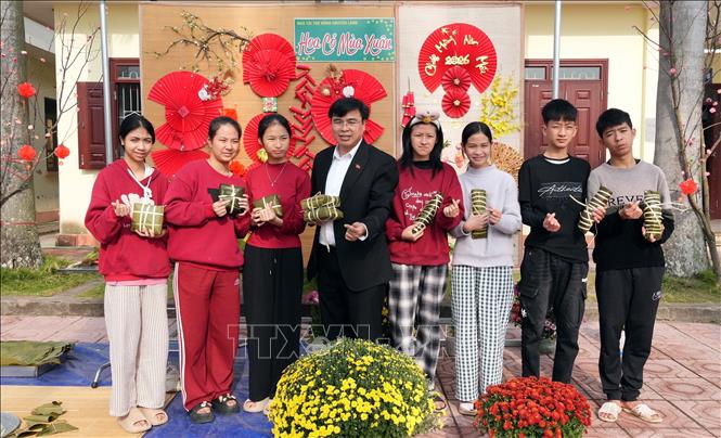 Giám đốc Cơ sở Bảo trợ xã hội tổng hợp Bắc Ninh Nguyễn Văn Huế cùng trẻ khuyết tật với những chiếc bánh chưng xanh do chính tay các em chuẩn bị tại chương trình. Ảnh: Đồng Thúy-TTXVN