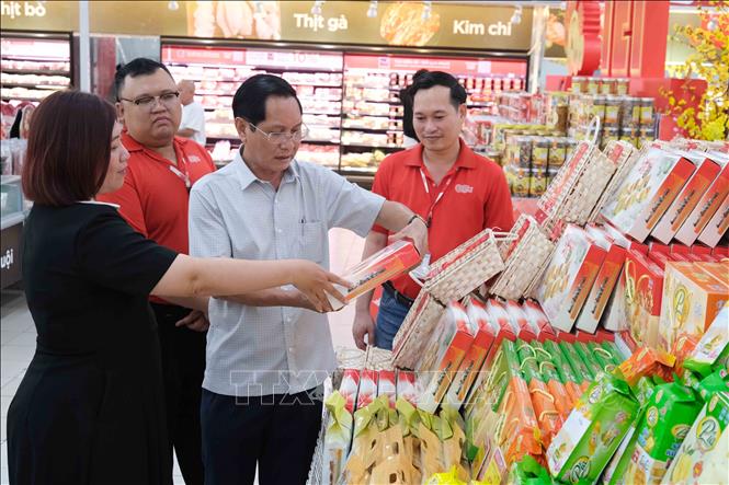 Phó Giám đốc Sở Công Thương Cần Thơ Huỳnh Thanh Sử kiểm tra mặt hàng bánh kẹo Tết bày bán ở siêu thị GO! Cần Thơ. Ảnh: Thanh Liêm - TTXVN