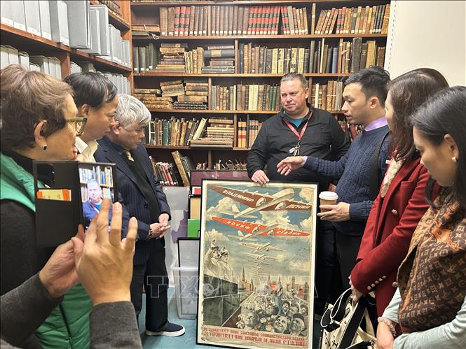 Ông Alex Gordon giới thiệu với các đại biểu Việt Nam về bức tranh áp phích của Liên Xô. Ảnh: Phong Hà-PV TTXVN tại Anh