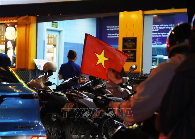 Cờ Tổ quốc gắn sẵn trên xe máy của một người hâm mộ để chuẩn bị “đi bão” nếu U23 lọt vào chung kết. Ảnh: Hồng Đạt - TTXVN