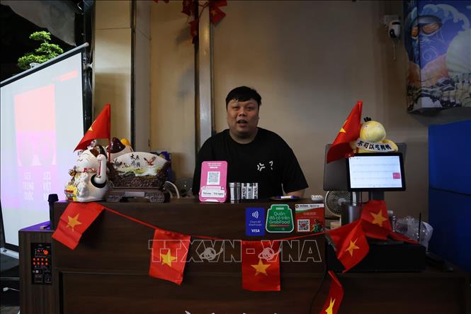 Anh Vương Trường Xuân Anh, chủ quán Tân Long Ký sẵn sàng khuyến mãi giảm giá cho thực khách xem trận U23 Việt Nam gặp U23 Trung Quốc. Ảnh: Hồng Đạt - TTXVN