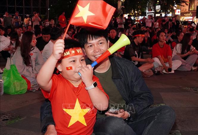 Hai bố con anh Đặng Hải Triều, phường Hoà Hưng, có mặt từ rất sớm để chọn cho mình vị trí tốt nhất cổ vũ đội tuyển U23 Việt Nam. Ảnh: Trung Tuyến - TTXVN 