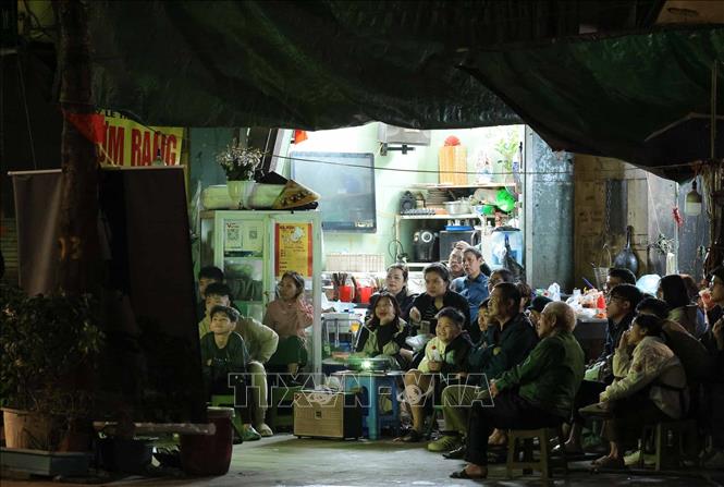 Người dân cùng nhau xem bóng đá trên phố Lê Thanh Nghị. Ảnh: Hoàng Hiếu - TTXVN