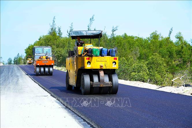 Máy móc thi công thảm nhựa tại Dự án đường trục ngang ven biển Thạch Hà. Ảnh: Hữu Quyết - TTXVN