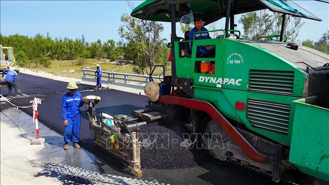 Máy móc thi công thảm nhựa tại Dự án đường trục ngang ven biển Thạch Hà. Ảnh: Hữu Quyết - TTXVN