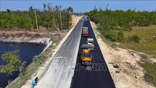 Máy móc thi công thảm nhựa tại Dự án đường trục ngang ven biển Thạch Hà. Ảnh: Hữu Quyết - TTXVN
