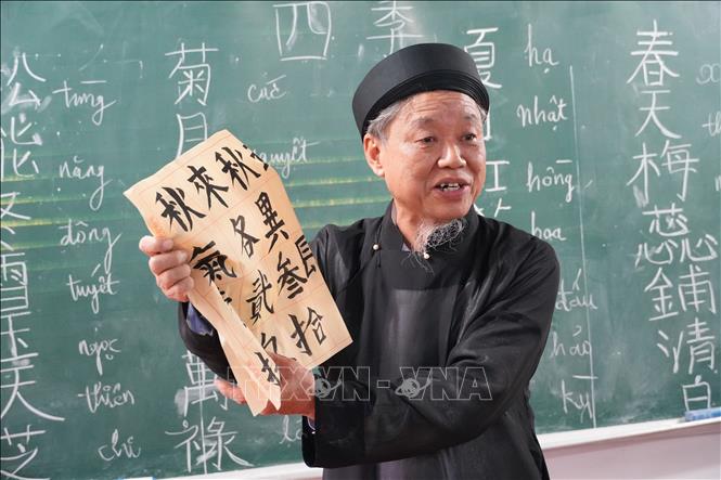 Cụ Vũ Văn Cứu say mê giảng từ chữ Hán Nôm cho các cụ cao niên trong lớp học. Ảnh: Nguyễn Thảo - TTXVN