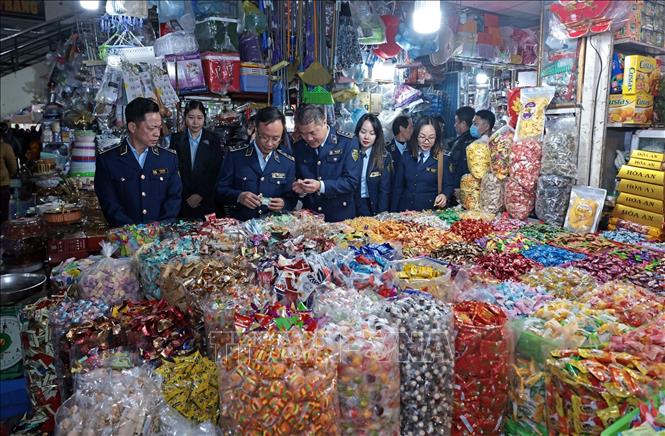 Đoàn kiểm tra một quầy bán bánh, kẹo tại chợ Hà Đông, Hà Nội. Ảnh: Trần Việt - TTXVN