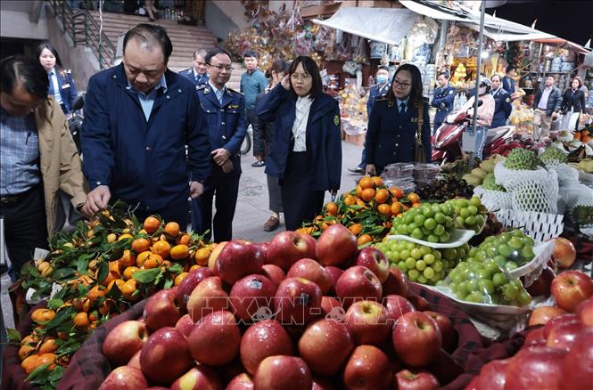 Đoàn kiểm tra một quầy kinh doanh trái cây tại chợ Hà Đông, Hà Nội. Ảnh: Trần Việt - TTXVN