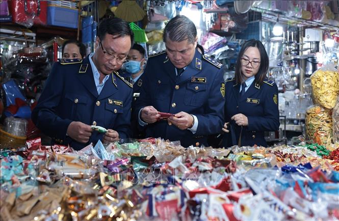 Đoàn kiểm tra một quầy bán bánh, kẹo tại chợ Hà Đông, Hà Nội. Ảnh: Trần Việt - TTXVN