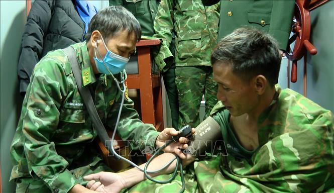 Lực lượng biên phòng thăm khám cho các nạn nhâu sau khi được cứu sống. Ảnh: TTXVN phát