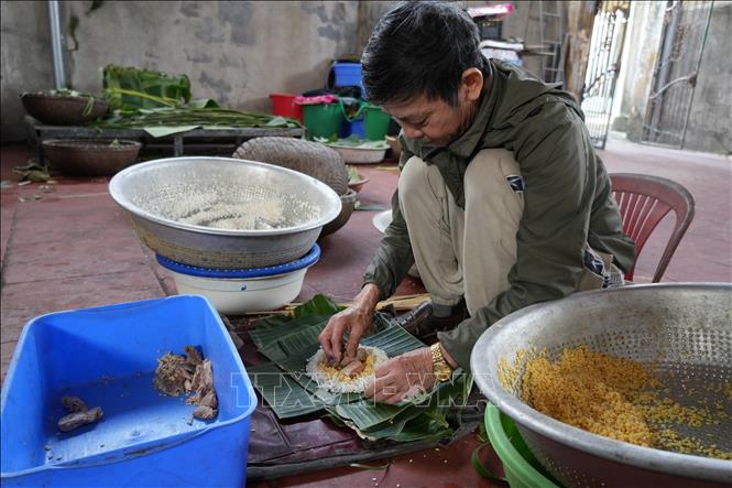 Ông Nguyễn Tất Lớ, làng Thủy Đường, gói bánh. Ảnh: Tiến Vĩnh –TTXVN