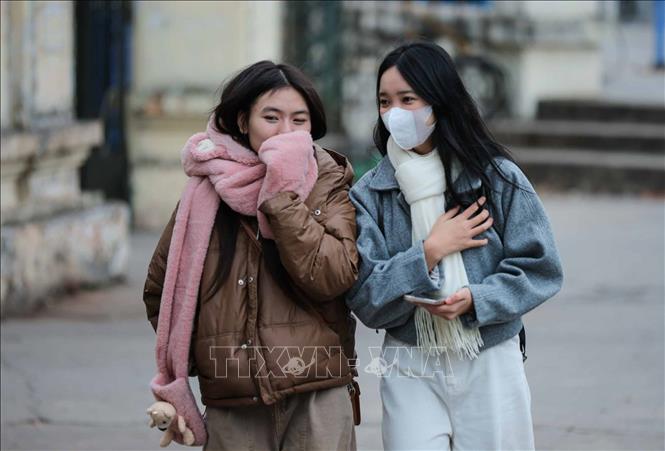 Người dân ra đường đều mặc áo ấm, khẩu trang, khăn quàng cổ để đảm bảo sức khoẻ khi phải ra ngoài trời. Ảnh: Hoàng Hiếu - TTXVN