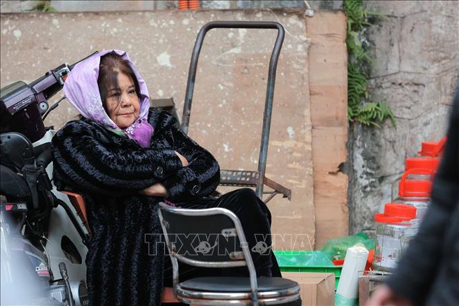 Một người bán hàng co ro trong tiết trời lạnh. Ảnh: Hoàng Hiếu - TTXVN