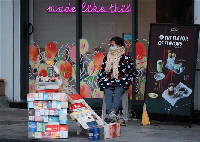 Một người bán hàng gần khu vực Thuỷ Tạ co ro khi Hà Nội đang đón đợt rét nhất từ đầu mùa. Ảnh: Hoàng Hiếu - TTXVN