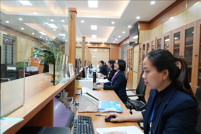 Cán bộ trung tâm giải quyết thủ tục hành chính cho người dân. Ảnh: Tiến Vĩnh –TTXVN