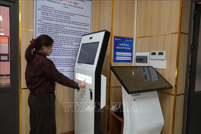 Người dân lấy số thứ tự tại Trung tâm phục vụ hành chính công xã An Lão. Ảnh: Tiến Vĩnh –TTXVN