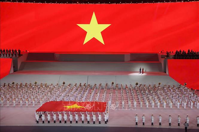 Đại biểu cùng khán giả thực hiện nghi lễ chào cờ. Ảnh: TTXVN